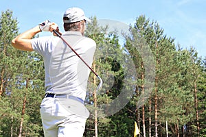 Athletic young man playing golf in golfclub