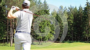 Athletic young man playing golf in golfclub