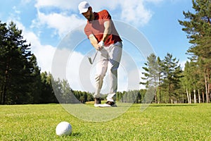 Athletic young man playing golf in golfclub.