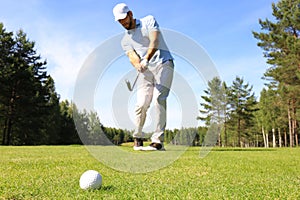 Athletic young man playing golf in golfclub photo