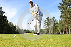 Athletic young man playing golf in golfclub