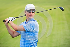 Athletic young man playing golf