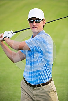 Athletic young man playing golf