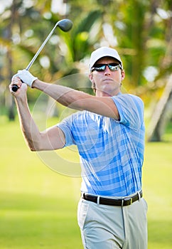 Athletic young man playing golf