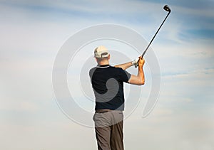 Athletic young man playing golf, golfer hitting fairway shot