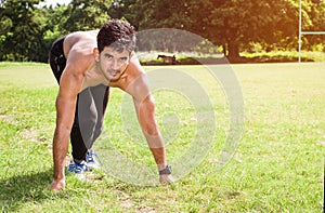 Athletic young man running in the sports ground. Healthy lifestyle , fitness and sports concept.