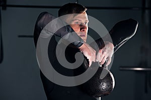 Muscular male adult exercising with kettle bell