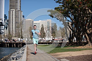 Athletic young runner. Urban sports. Man jogging and running for fitness in the city on a beautiful summer day.