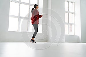Athletic young sportswoman working out with jumping rope