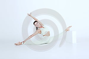 An athletic young woman doing yoga isolated on a white background is a healthy lifestyle concept.