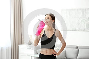 Athletic young woman drinking protein shake