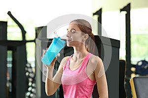 Athletic young woman drinking protein shake