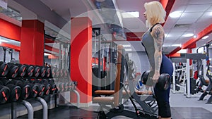 Athletic young woman lifting dumbbells at the gym