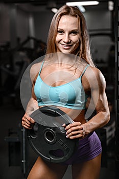 Athletic young woman model posing and exercising fitness workout