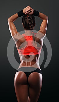 Athletic young woman showing muscles of the back