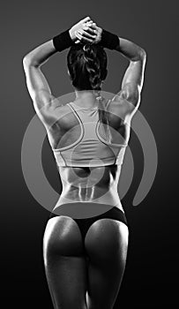 Athletic young woman showing muscles of the back