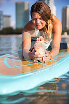 Athletic young woman in SUP Yoga practice front stretch in Ala M