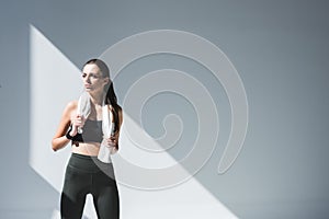 athletic young woman with towel looking away