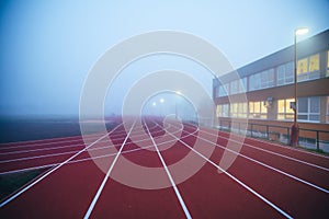 Athletics red Track in morning mist. Sport photo