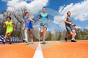 Athletics teenage boys running on the racetrack photo