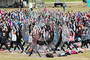 People Do Upward Salute Pose In Large Outdoor Yoga Class