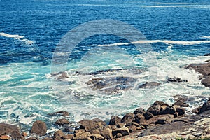 Aguas revueltas y olas rompiendo contra las rocas en la costa atlantica photo