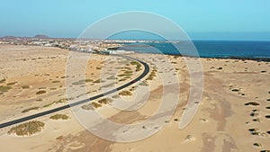 Atlantic ocean coastline. Aerial view of highway road, Corralejo sand beach, outskirts. Aerial landscape of city. Road