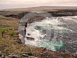 Atlantic ocean crushes powerful waves on cliff rocks. Landscape in Inis mor Aran Islands, county Galway, Ireland