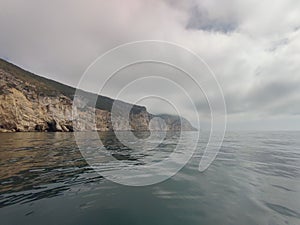 Ocean and fog covering the cliff in Sintra-Cascais Natural Park, Portugal photo