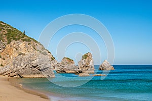 Atlantic Ocean at Ribeiro do Cavalo beach with rocks and cliff, Sesimbra PORTUGAL