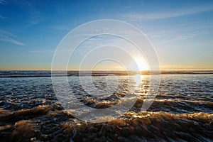 Atlantic ocean sunset with surging waves at Fonte da Telha beach, Portugal photo