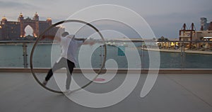 Atlantis hotel in the background of a man doing wheel gymnastics, 4k