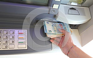 Atm and banknotes in euro and the hand