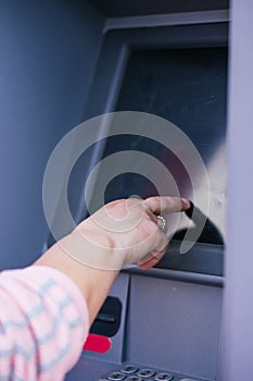 ATM keyboard with woman& x27;s hand is entering the number in the ATM