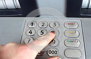 Female hand dials at an ATM pin code to get money