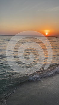 The atmosphere of the beach in the afternoon, with the calming waves and the setting sun