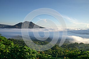 The atmosphere of Mount Batur in the morning where the caldera is covered by low stratus clouds. The sky looks bright blue and