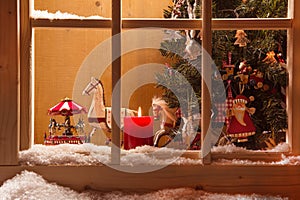 Atmospheric Christmas window sill decoration:snow,tre e,candle,rocking horse and carousel photo