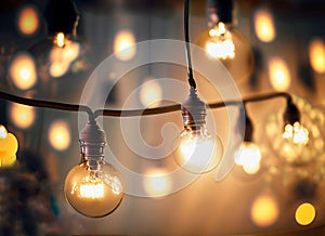 Atmospheric, festive lighting with hanging illuminated light bulbs in the night