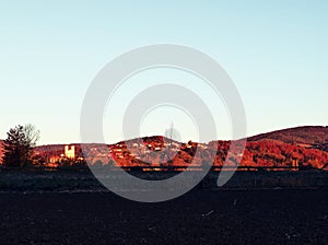 Atmospheric red shiny hill in sunrise light in picturesque autumn landscape