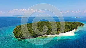 Atoll with a beautiful island, aerial view. White sand beach and blue sea. Mahaba Island, Philippines.