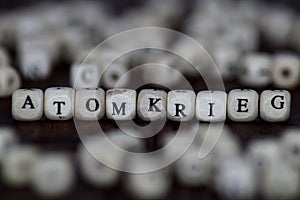 ATOMKRIEG word written on wood cube with dice background