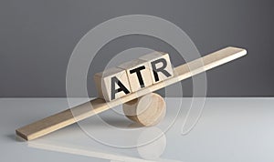 ATR on wooden cubes on wooden balance , business concept
