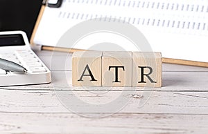 ATR word on a wooden block with clipboard and calcuator