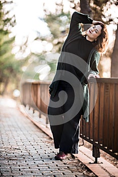 Atractive Happy Woman Standing by a Wooden Fence in the Forest,