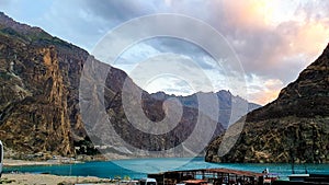 Attabad lake a renown lake in Hunza Valley Pakistan with boat in the water and beautiful mountains covered with clouds photo