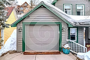 Attached garage of a house with gable roof and gray cladding on exterior wall