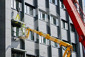 Attaching the finishing element of the house facade using a scissor lift