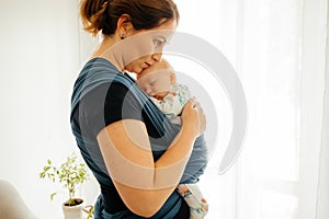 Attachment parenting concept. Young mother with baby in sling