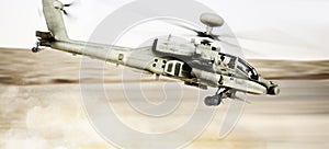 Attack Apache longbow helicopter gunship flying fast and low with dust debris in its wake.